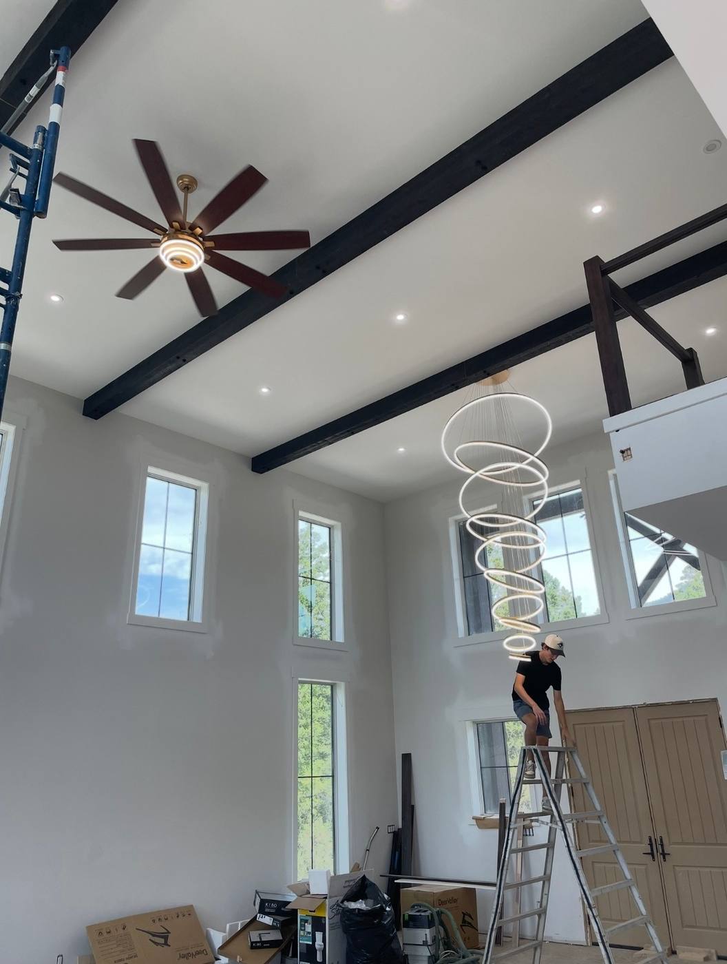 Ceiling fan and large ring chandelier installed in a residential home